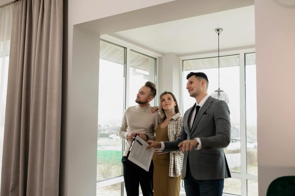 pexels-photo-7641860-7641860 A real estate agent showing a modern home to a young couple during a daytime viewing.